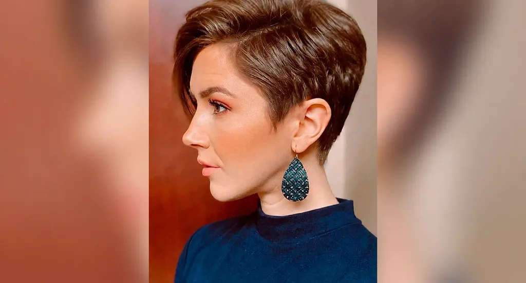 Profile of a woman with a clean, brown tapered pixie haircut featuring closely cropped sides and a fuller crown.